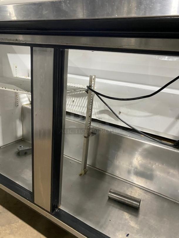 True Commercial Stainless Steel 2 Door Prep Table, Model TSSU-48-12, with cutting board and poly-coated rack. On casters.