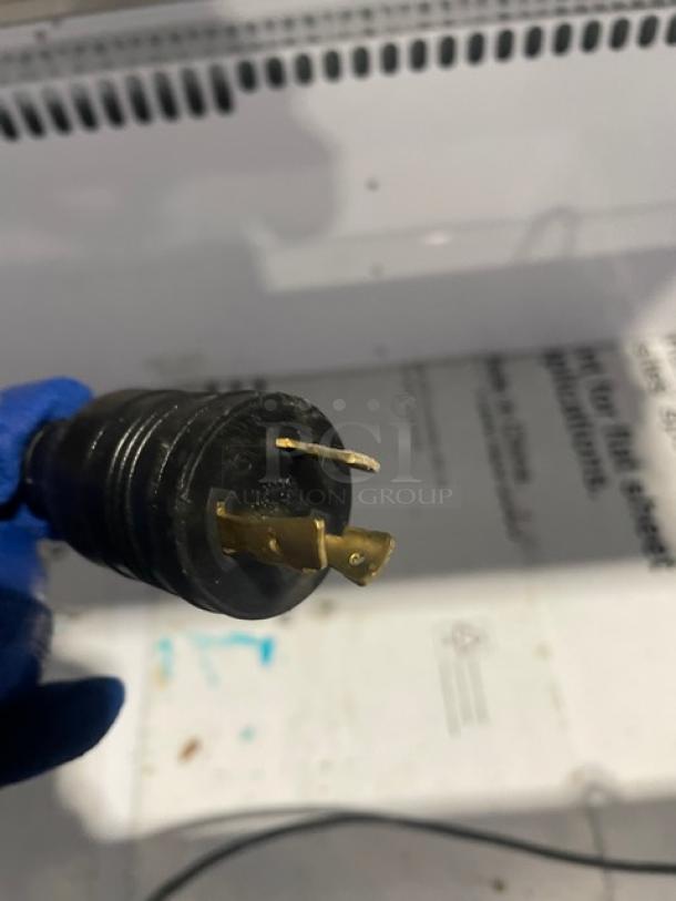 Close-up of the plug from a Vendo NIC183S02 freezer, showcasing a three-prong connector for 220V 1 Phase power.
