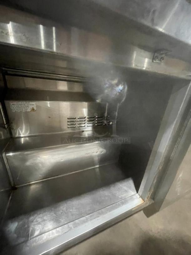 Avantco 178SSUC60RHC 2-door stainless steel undercounter refrigerator interior with shelves, model label, and casters.