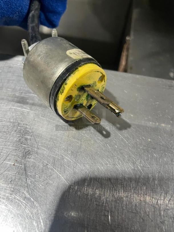 Plug and metal surface, showing wear and corrosion on the plug prongs.