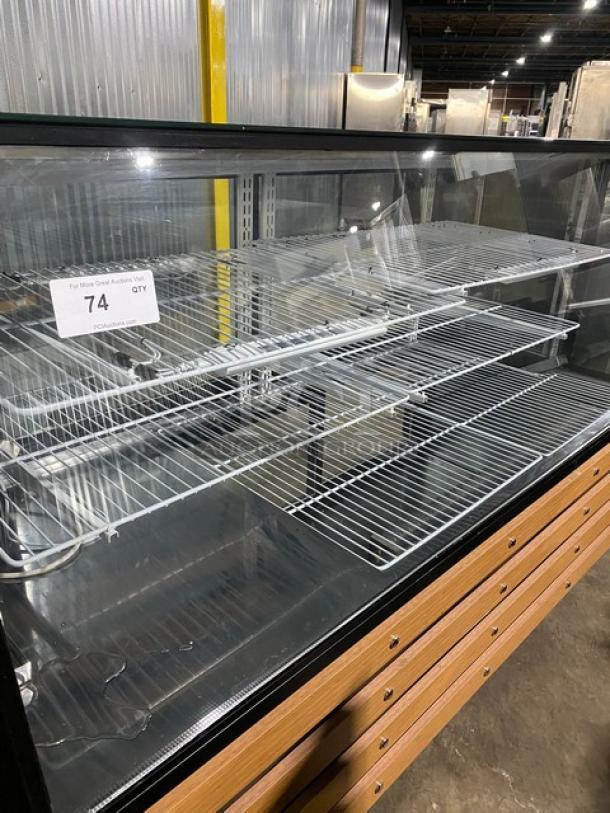 Commercial black 72" slanted glass refrigerated deli display with dual glass sliding doors, poly coated racks, and casters.