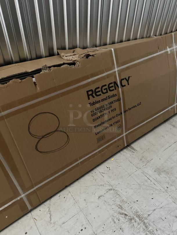 Regency 24" x 120" stainless steel work table, 16-gauge, with 4" backsplash and undershelf, in original packaging.