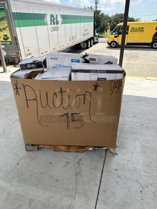 Mixed pallet of packaged items in a large cardboard box labeled "Auction 15" on a wooden pallet.