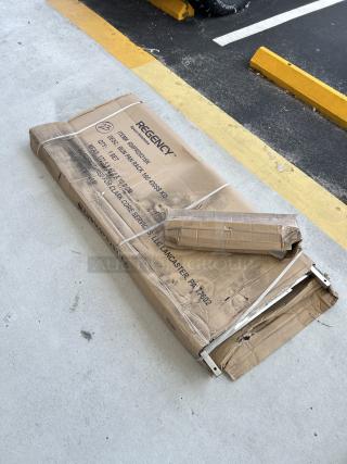 Brand new Regency 20 Pan End Load Rack in original packaging. Model 600PR20316K, minor dents/scratches visible on box.