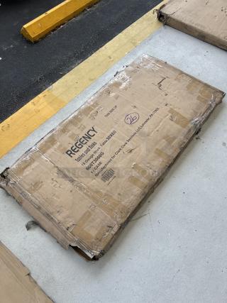 Regency 30"x60" stainless steel work table, model 600T3060G, in worn box. Features galvanized legs and undershelf.