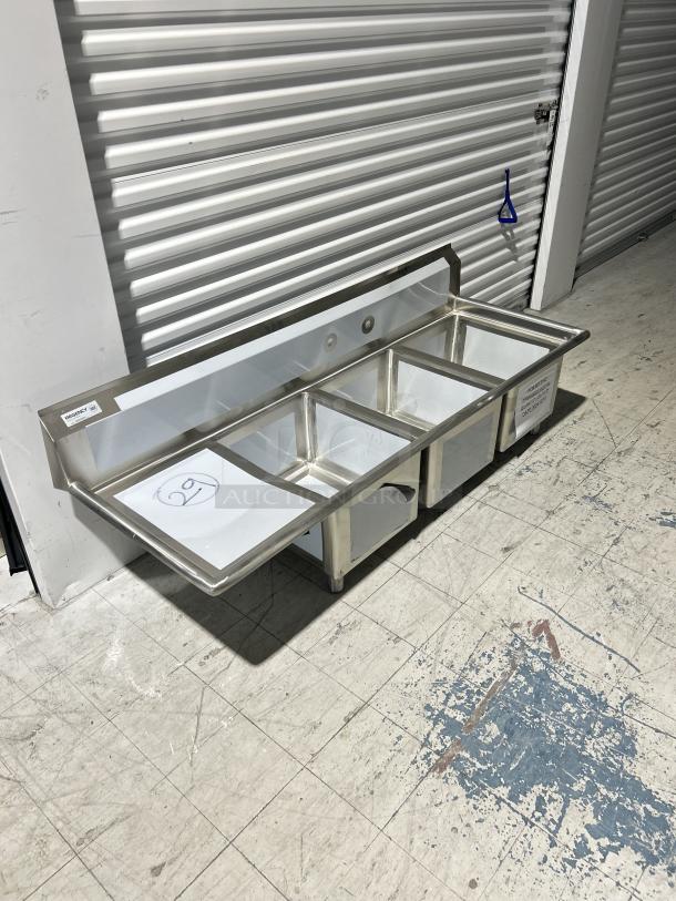Regency 3 compartment sink, model 600S3162018L, with left drainboard. Features 16"x20"x18" bowls, brand new, with minor scratches.
