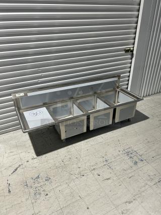 Brand new Regency 3 compartment sink, model 600S3162018L, with left drainboard. Minor scratches and dents visible.