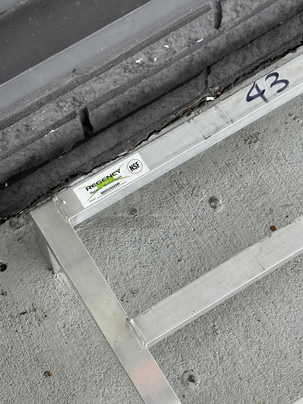 Regency 600DUN24248 aluminum dunnage rack, 24"x24"x8", 1,500 lb. capacity, scratch and dent condition, NSF label visible.