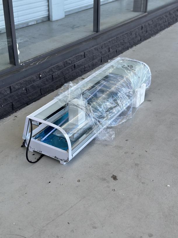 Brand new Aventco 360RSD60HC 60" refrigerated sushi display case. Notable scratch and dent with broken glass visible.