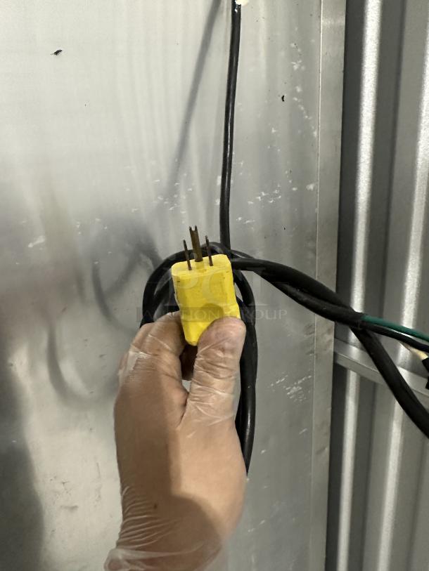 Close-up of a yellow power plug for a used True Refrigerator, model 3025342, showing electrical connection condition.