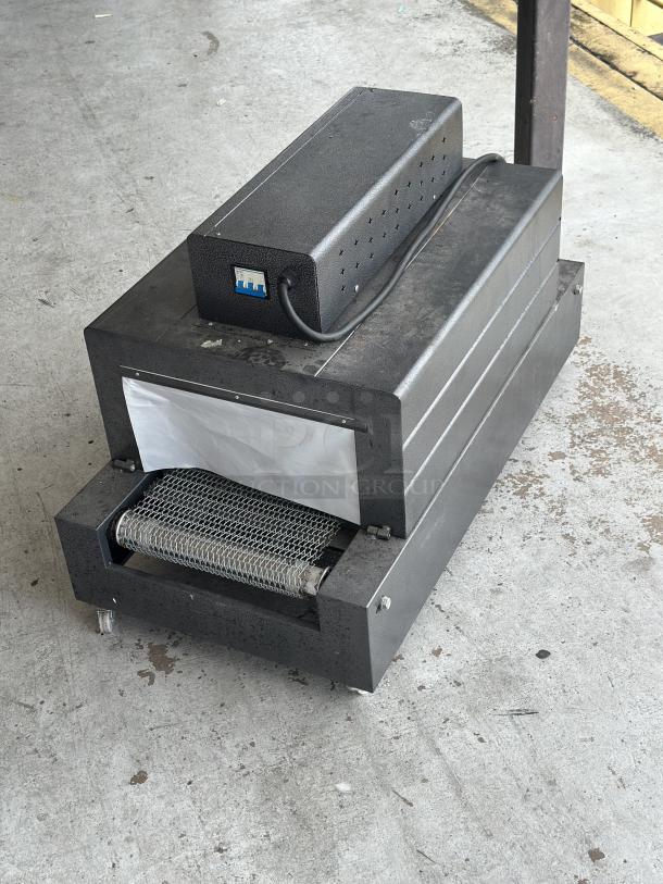 Used conveyor toaster oven in good condition, features a metal body, top-mounted control box, and wire mesh conveyor.