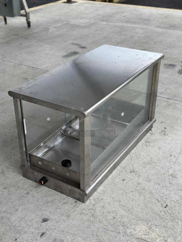 Used stainless steel food display warmer case, glass panels, visible control knob, in good condition, for kitchen use.