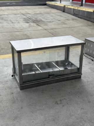 Used food display warmer case with stainless steel frame and glass panels. Features dual compartments; minor wear visible.