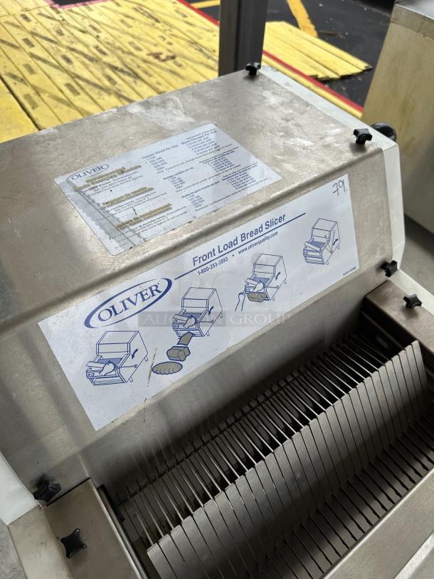 USED Oliver Front Load Bread Slicer with stand, stainless steel, visible slicing blades, instructional labels.