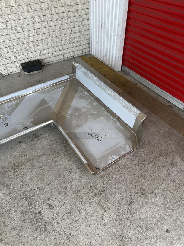 Brand new Regency 6' L-shape dishtable, 16-gauge stainless steel, left island, minor scratches and dents visible.