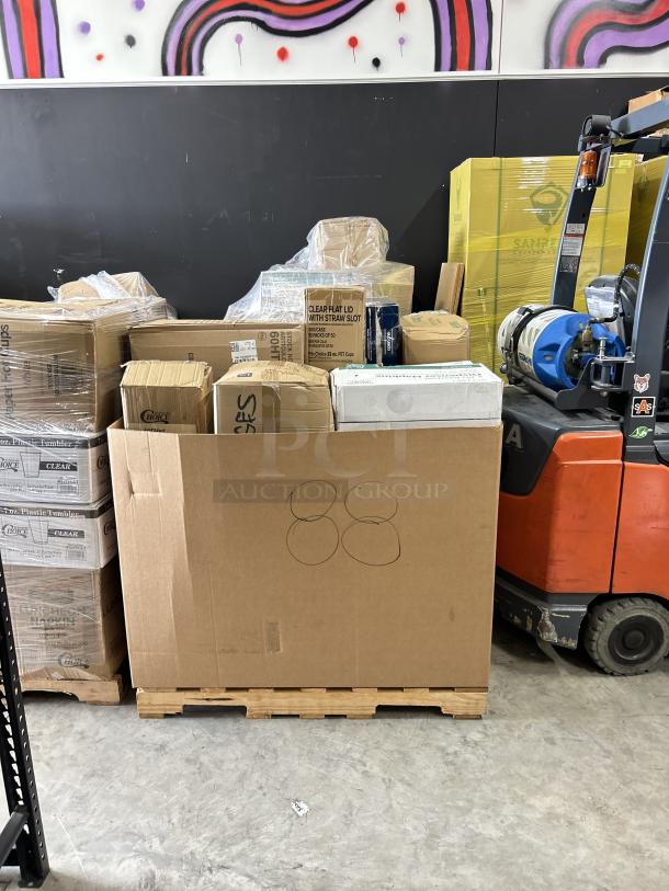 Mixed pallet with boxed paper and plastic items including napkins, cups, lids, and bags, all brand new and ready for auction.