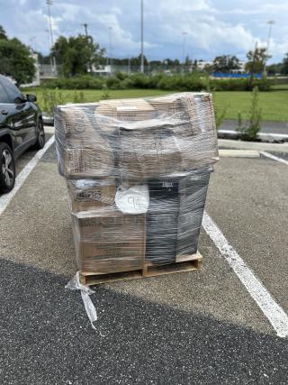 Mixed pallet with brand new boxed items, including Lavex black 23-gallon trash can, PET plastic cold cups, and disposable gloves.