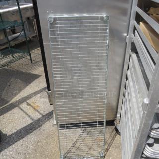 Metal Metro shelf, 42x14 inches, silver, in good condition, vertical wire grid design, outdoor setting.