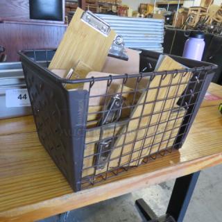 Metal basket filled with wooden guest check holders, featuring metal clips. Basket in good condition on a wooden table.