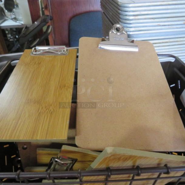 Metal basket containing multiple guest check holders with clipboards, wood and cork materials, in good condition.