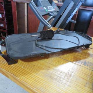 Presto electric griddle, black, missing grease cup, with power cord, on wooden surface.