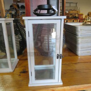 White patio lantern with glass panels, metal latch, and black handle. In good condition. Suitable for outdoor use.