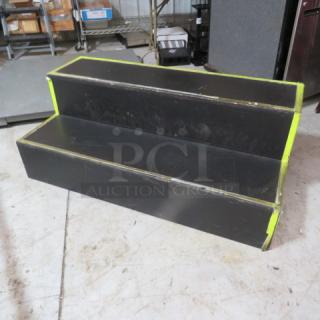 Wooden two-step stage/equipment stand, 48x24x18 inches, black with neon edges, used condition, sturdy construction.