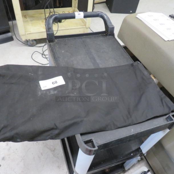Black stage cover, fabric material, laid on a cart. Tag marked "68." Slight wear, suitable for stage equipment protection.