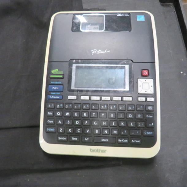 Brother P-Touch label maker with keyboard, screen, and control buttons, in used condition. Model information not visible.