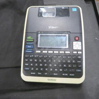 Brother P-Touch label maker with keyboard, screen, and control buttons, in used condition. Model information not visible.