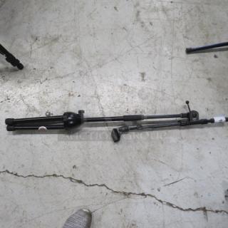 Collapsible black mic stand on concrete floor, adjustable height, good condition.