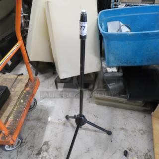 K&M mic stand with adjustable height, tripod base, good condition, auction tag labeled "77" attached to shaft.