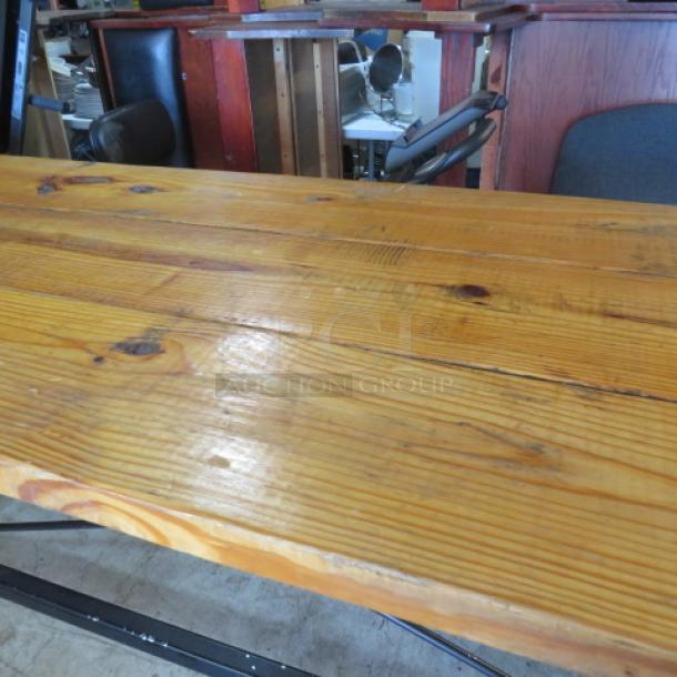 Solid wood bar-height table with black metal industrial base, 96x28x42 inches. Polished finish, excellent condition.