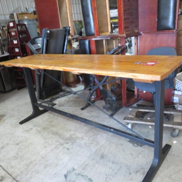 Solid wood bar-height table with black metal industrial base, 96x28x42 inches. Appears in used condition.