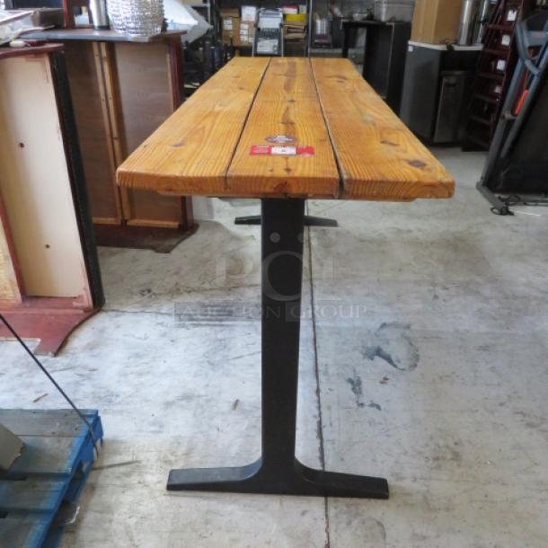 Solid wood bar-height table with black metal industrial base, measuring 96x28x42 inches. Excellent condition.
