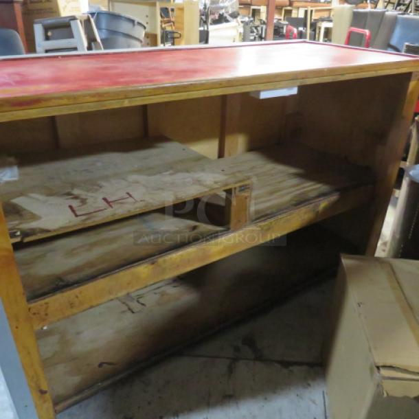 Wooden metal hostess stand with red top, three under shelves, dimensions 67x28x41 inches. Visible wear and markings.