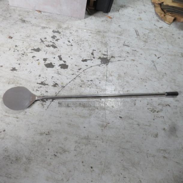 Stainless steel pizza paddle with a long handle, used, durable, suitable for commercial kitchens.