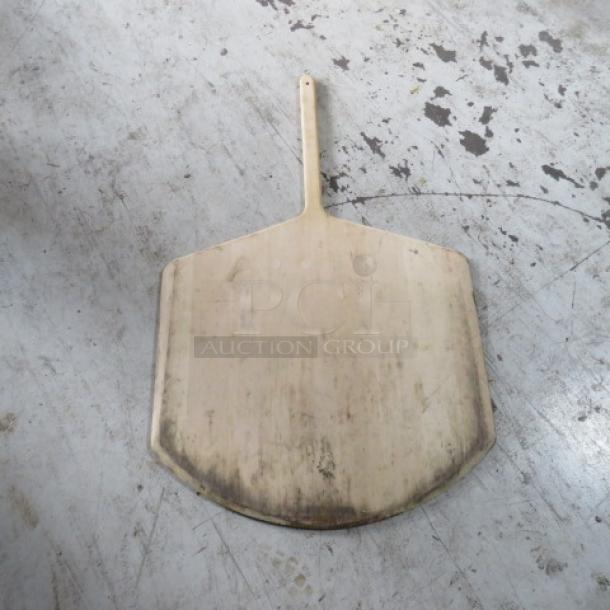 MPI wooden pizza paddle, 26x42 inches, showing signs of wear with a sturdy handle. Perfect for baking enthusiasts.