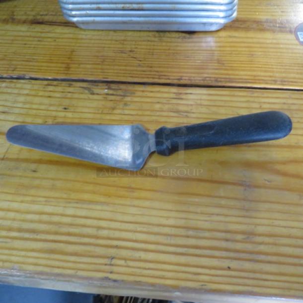 Stainless steel pizza/pie server with black plastic handle, used condition. Model 5XBID.