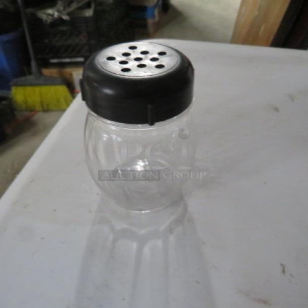 Clear glass cheese/pepper shaker with black perforated lid, model 12XBID, in good condition.