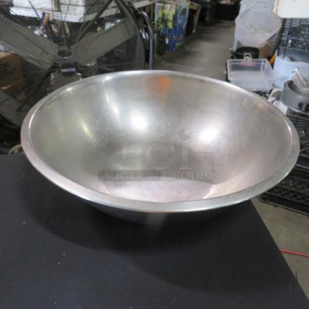 16-inch stainless steel mixing bowl, slightly worn. Ideal for large recipes, durable kitchenware. No visible markings.