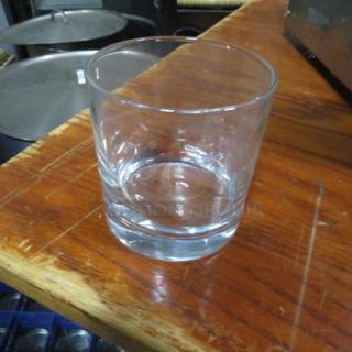 Clear glass, round rocks glass on wooden surface, excellent condition, ideal for serving beverages.