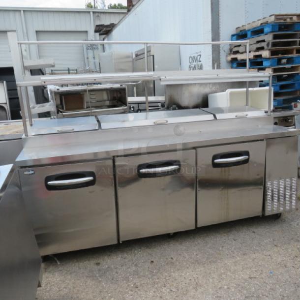 Turbo Air PT93 3-door prep table with 3 racks, overshelf, 2 ticket rails, on casters. 115V, 93x32x69. Condition: not cooling.
