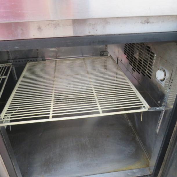 Turbo Air PT93 3 Door Prep Table interior with rack, metal casing, and fan vent. Note: Unit not cooling. Model PT93, 115V.
