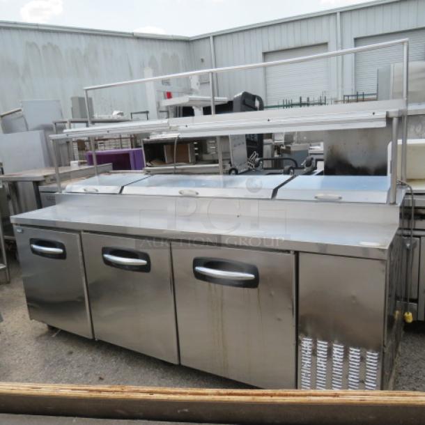 Turbo Air PT93 3-door prep table with overshelf, 2 ticket rails, and 3 racks on casters. 93x32x69 inches. Not cooling.