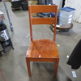 Solid wood chair with a high back, showing a natural finish and minor wear. Item code 5XBID on visible tag.