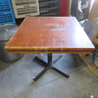 Solid wood table on pedestal base, 33x36x29 inches, with visible wear on the surface, indicating previous use.