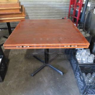 Solid wood table with flip-up sides, converting to 42-inch round, on pedestal base. Dimensions: 36x36x29 inches.