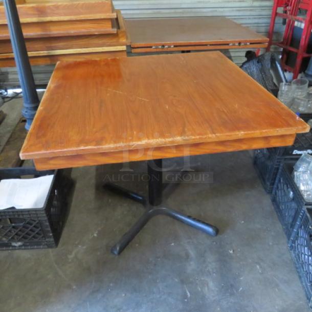 One solid wood table with pedestal base, 36x36x29 inches. Features a square top and metal base. Good condition.