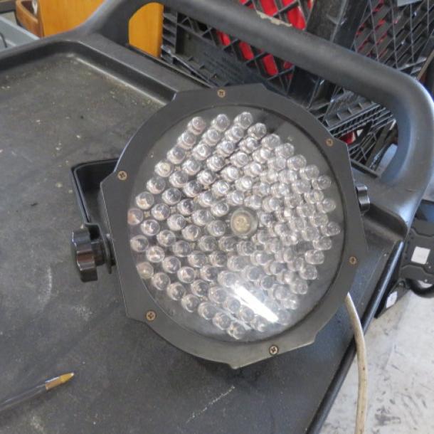 Stage light with bracket, featuring multiple LED bulbs. In working condition with visible power cord. Suitable for events.